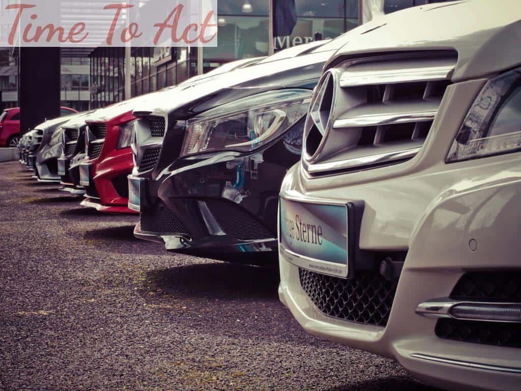 Luxury cars lined up at an outdoor dealership, showcasing sleek designs.