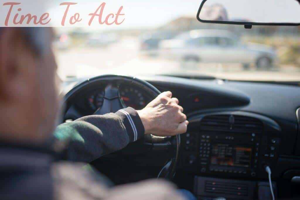 A Man in a Jacket Driving a Car