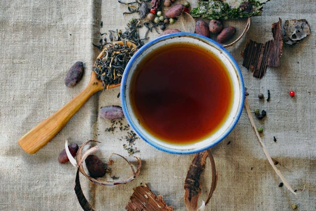 Taza de infusión rodeada de hierbas